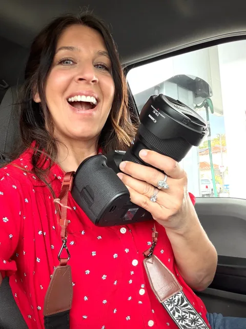 Jenn Miller laughing and holding a camera lens